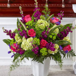 Pink roses and purple flowers in a white vase