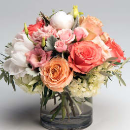Mixed pink, peach, and white roses in a glass vase