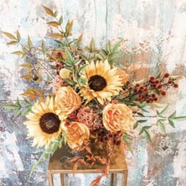 Sunflowers and peach roses in a gold vase