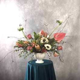 Large mixed floral arrangement in a white urn vase