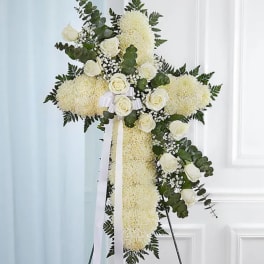 White floral standing cross with roses and ribbon