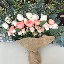 Bouquet of pink and white roses wrapped in burlap
