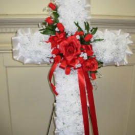 White floral cross with red roses and ribbon