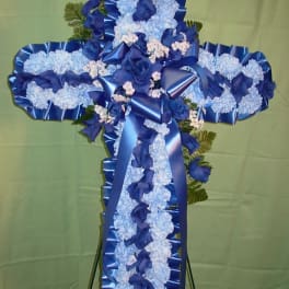 Blue and white floral cross on a stand with ribbon accents