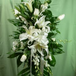 Tall white floral standing spray with lilies and ribbon