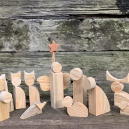 Wooden nativity scene figurines arranged on a rustic surface