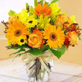 Orange and yellow mixed bouquet in a clear glass vase
