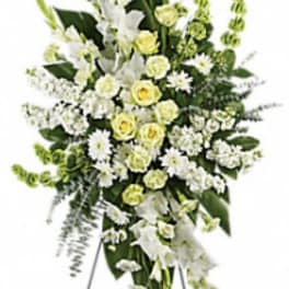 Tall white and pale yellow funeral spray on a standing easel