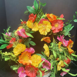 Colorful floral wreath with bright poppy-like blooms on a round base