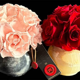 Two rose bouquets in round vases, one blush pink and one red