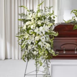 White funeral spray beside a casket