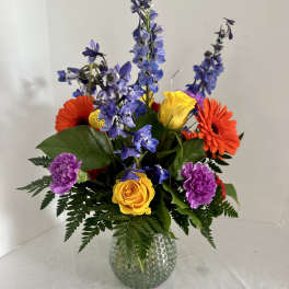Colorful mixed bouquet in a textured glass vase