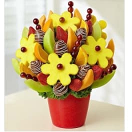 Fruit bouquet in a red pot with chocolate-dipped strawberries and melon flowers