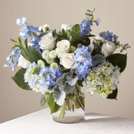 Blue and white flower arrangement in a clear glass vase