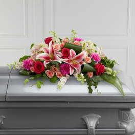 Pink and red floral casket spray with lilies and roses