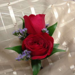Two red roses with purple filler wrapped in beige mesh