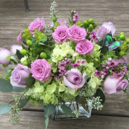 Pink roses and green hydrangeas in a square glass vase
