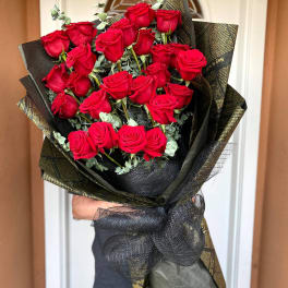Bouquet of red roses wrapped in black and gold paper