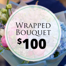 Wrapped bouquet with pink, white, and blue flowers