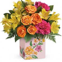 Orange roses and pink carnations in a floral-painted box