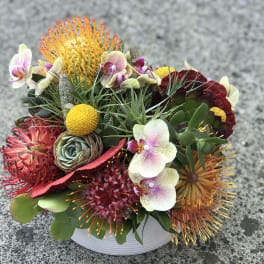Colorful mixed floral arrangement in a white bowl vase
