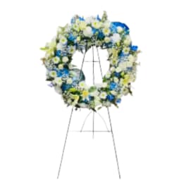 Blue and white floral wreath on a metal stand