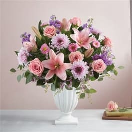 Pink and lavender flower arrangement in a white vase