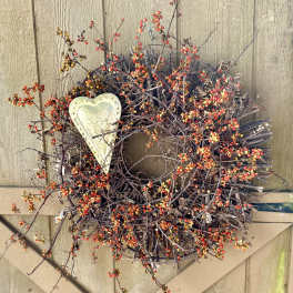 Twig wreath with red berries and a metal heart accent