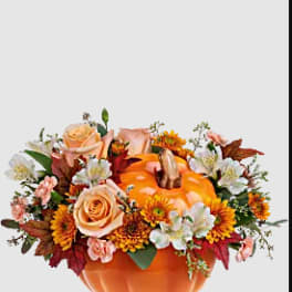 Pumpkin-shaped container with peach roses and orange flowers