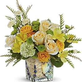 Bouquet of yellow and white roses in a decorative glass vase