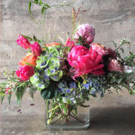Mixed pink and purple floral arrangement in a clear glass vase