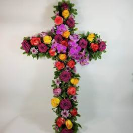 Cross-shaped floral arrangement with multicolored roses and purple orchids
