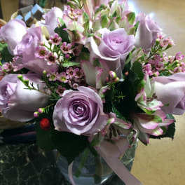 Lavender roses and pink-white alstroemeria in a glass vase with ribbon