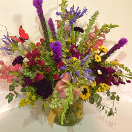 Colorful mixed bouquet in a glass vase with a yellow ribbon