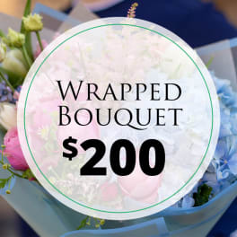 Wrapped bouquet with pink, white, and blue flowers