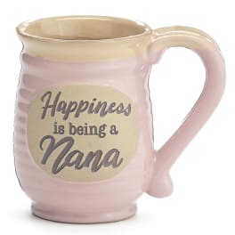 Pink ceramic mug with beige rim and oval plaque reading “Happiness is being a Nana.”