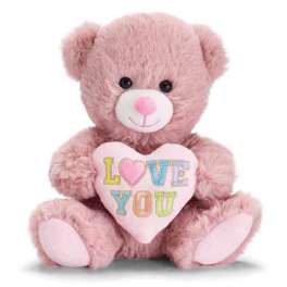 Pink plush teddy bear holding a pastel heart pillow with the words LOVE YOU.