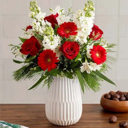 Red roses and gerbera daisies in a white vase