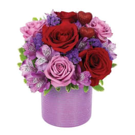 Pink and red rose arrangement in a lavender container