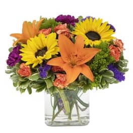 Bouquet of sunflowers and orange lilies in a clear glass vase