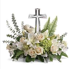 White floral arrangement with a silver cross centerpiece