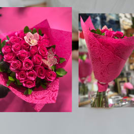 Bouquet of hot pink roses with a single pale orchid in embossed pink wrap.
