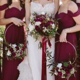 Bride and bridesmaids holding burgundy floral hoops