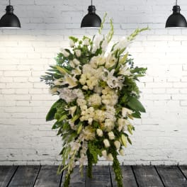 Large white floral standing spray with lilies and roses