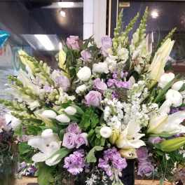 Large lavender and white floral arrangement in a black vase
