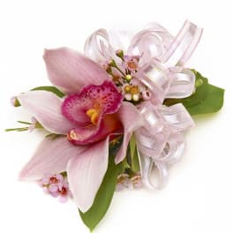 Pink cymbidium orchid corsage with tiny pink blossoms and a sheer pink ribbon bow.