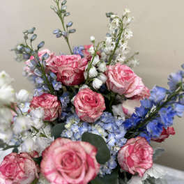 Pink roses, blue delphinium, and hydrangeas