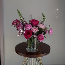 Pink and magenta flowers arranged in a clear glass vase