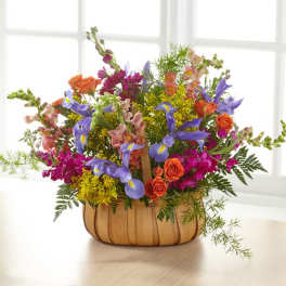 Colorful mixed flower arrangement in a wooden basket