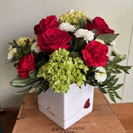 Bouquet of red roses, carnations, white daisies, and green hydrangea in a white box